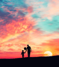 Silhouette of men on golf course against sky during sunset