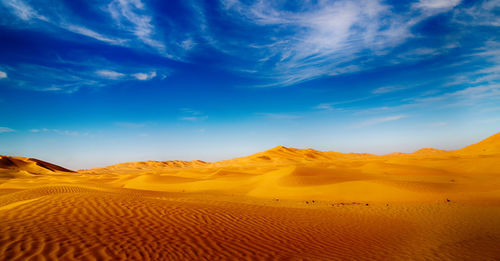 Scenic view of desert against blue sky