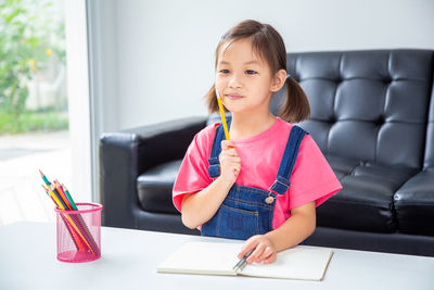 Portrait of smiling girl sitting on table