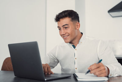 Side view of man using laptop at office