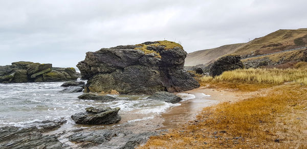 Rock formation in sea against sky