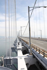 Suspension bridge over sea against sky