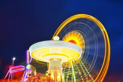 Low angle view of illuminated ferris wheel against sky at night