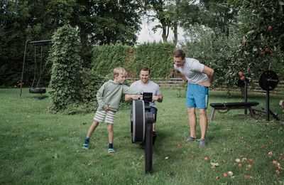 Two men and their son working out at their home gym in the garden