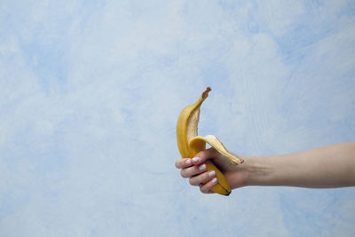 View of woman's hand holding holding banana
