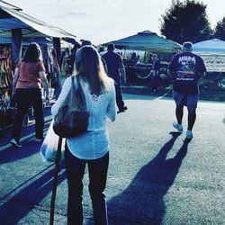 Rear view of people standing against sky