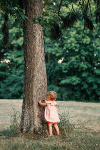 Girl standing on tree trunk