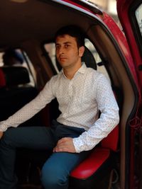 Portrait of young man sitting in car