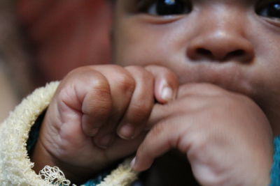 Close-up of baby boy with finger in mouth