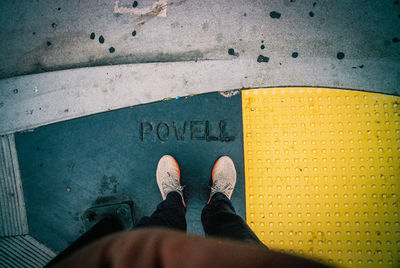 Low section of man standing on road