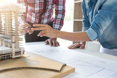 Engineers examining building model at desk in office