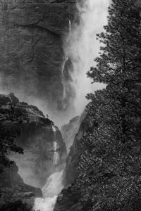 Low angle view of waterfall on rocks