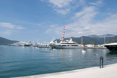 Boats moored at harbor against sky