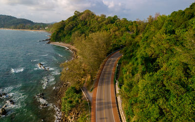 High angle view of road amidst trees against sky