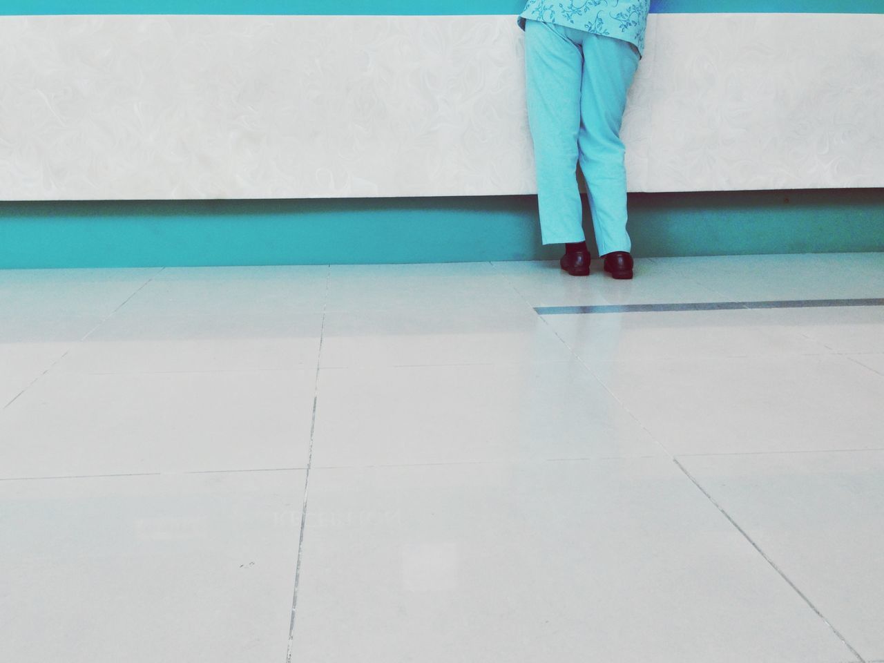 low section, person, blue, standing, men, lifestyles, tiled floor, walking, indoors, copy space, human foot, day, wall - building feature, shoe, leisure activity, white color