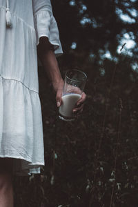 Midsection of man holding ice cream standing outdoors