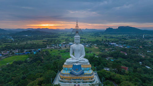 Aerial image of a large buddha statue at wat nong hoi temple in ratchaburi, thailand.