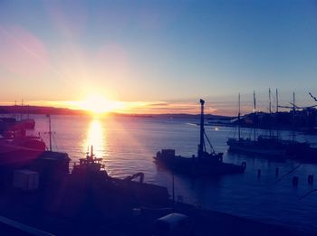Boats in harbor at sunset