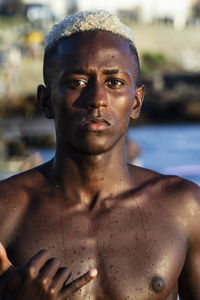 Portrait of shirtless man standing at beach