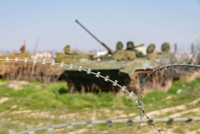 Metal fence by plants against sky