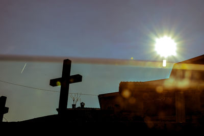 Silhouette cross against sky during sunset