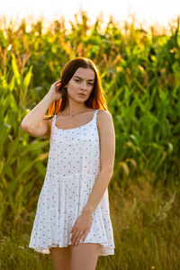 Young woman standing against plants