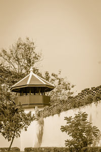 Built structure by trees against sky