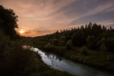 Scenic view of river against sky at sunset