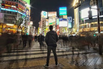 People walking on illuminated street at night