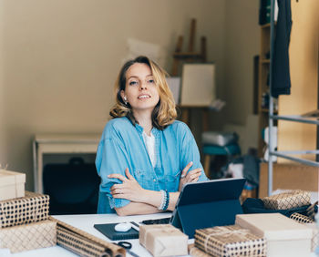 Portrait of a smiling young woman sitting on table