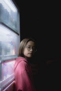 Portrait of girl standing by vending machine