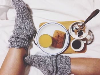 Low section of person having breakfast in bedroom