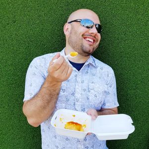 Man wearing sunglasses eating food