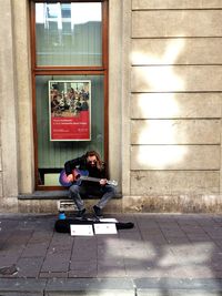 Full length of couple sitting outdoors