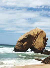 Scenic view of cliff and sea against sky