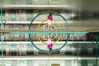 Digital composite image of woman standing against play equipment in city
