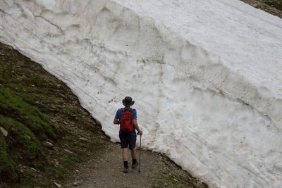 Rear view of man hiking by glacier