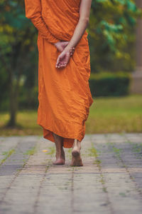 Low section of monk walking on footpath