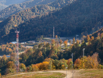 Trees and plants by buildings against mountain during autumn