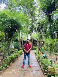 Full length portrait of boy standing against plants