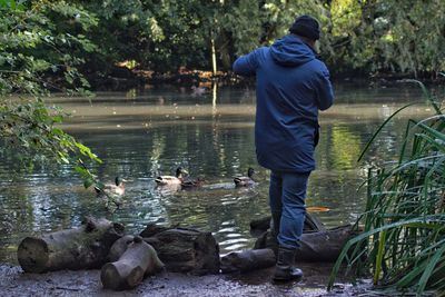 Man taking photos at the duck pond in the woods