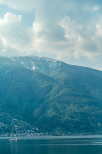 Scenic view of sea and mountains against sky