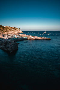 Scenic view of sea against clear blue sky