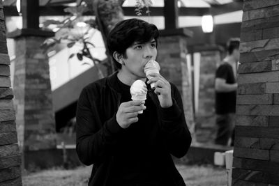 Young man looking away while having ice creams