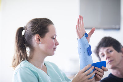 Nurse tigthing a armbracer to a patient female