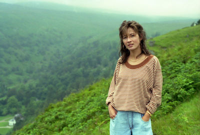 Portrait of beautiful young woman standing on land