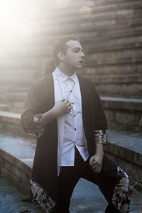 Young male model standing on steps during sunset