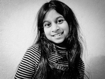 Portrait of smiling girl against wall