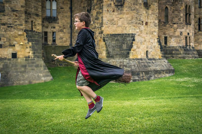 Boy with magician costume against alnwick castle
