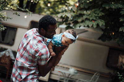 Father carrying daughter on shoulder outdoors